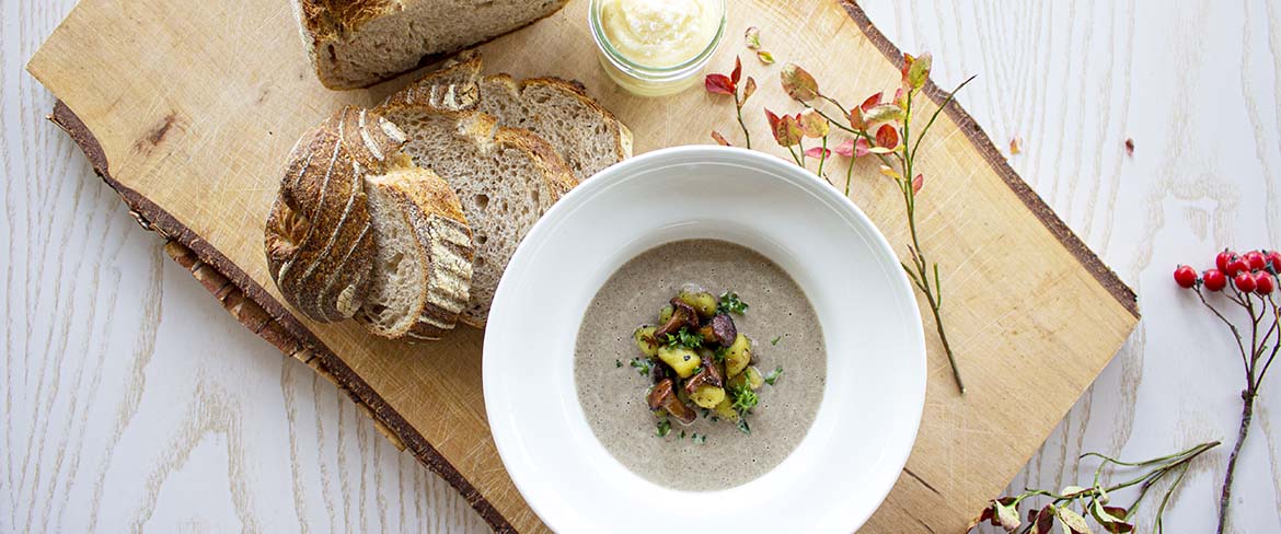 Soppa och bröd serverat på en träbricka