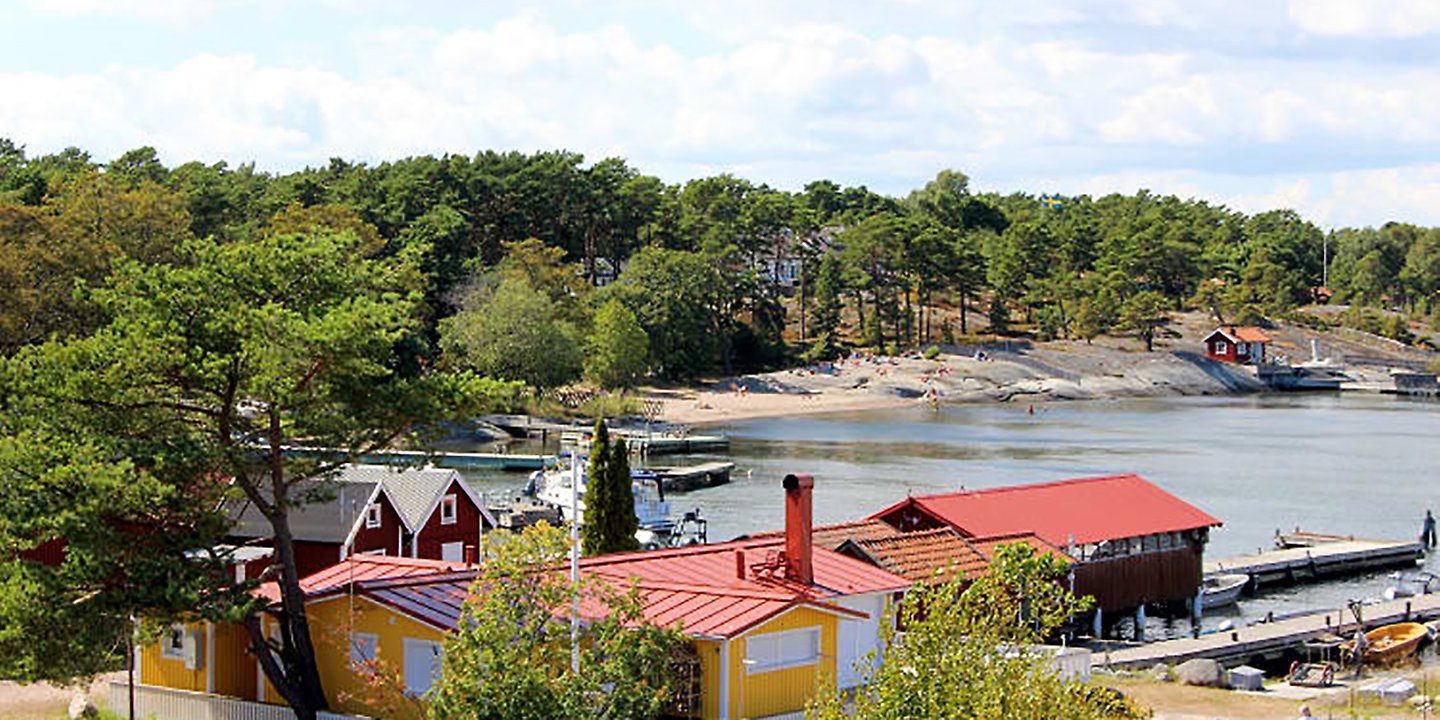 vy på hustak, klippor och hav fläskberget badstrand i sandhamn