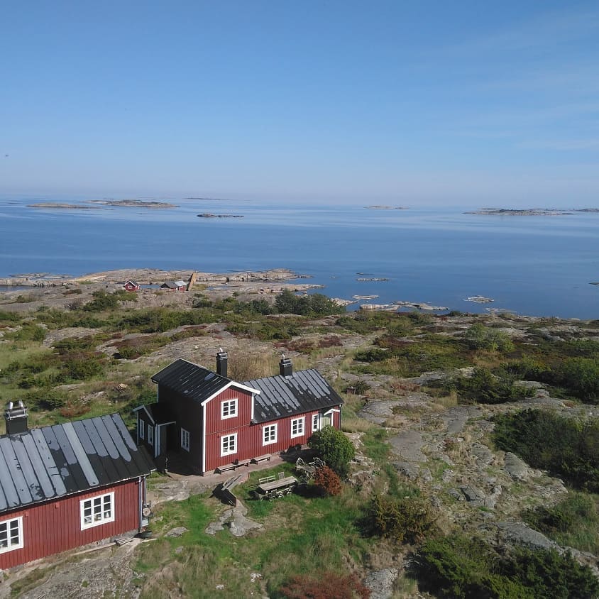 röda hus med vita knutar på klippor i ytterskärgården sandhamnsguiderna