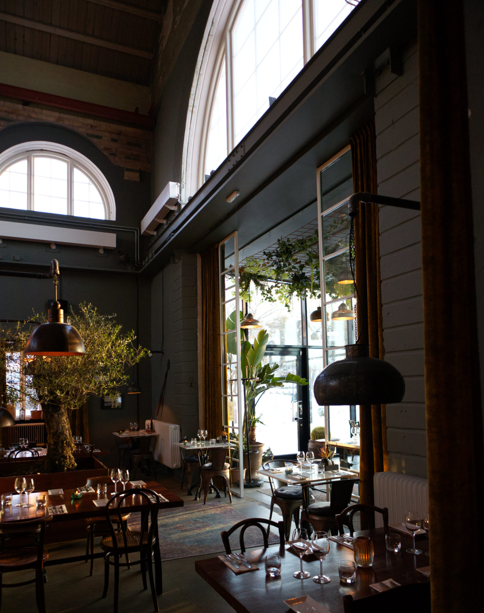 Restaurang med bord i en rustik lokal med högt i tak